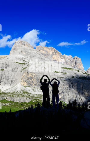 Silhouette, Wanderer auf dem Wanderweg 101 Form ein Herz mit ihren Händen, hinter ihnen Gipfel der Einser, Sextner Dolomiten Stockfoto