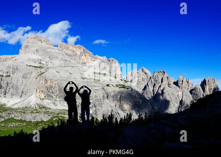 Silhouette, Wanderer auf dem Wanderweg 101 Form ein Herz mit ihren Händen, hinter ihnen Gipfel der Einser, Sextner Dolomiten Stockfoto