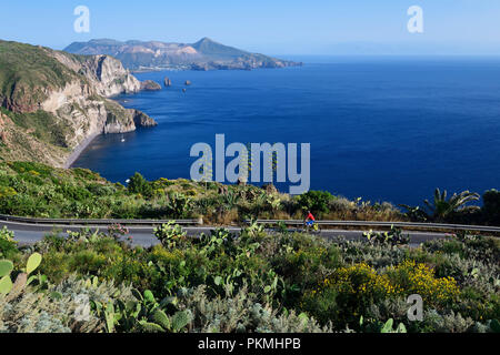 Radfahrer auf dem Belvedere Quattrocchi mit Blick über die Felsen Faraglione auf der Insel Vulcano, Pianoconti, Lipari Stockfoto