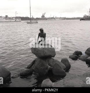 1950, historische, die Bronzeskulptur von Edvard Eriksen, 'Der kleine Mermiad' am Hafen Langelinie, Kopenhagen, Dänemark. 1913 erbaut und auf ein Zeichen aus einem Märchen von Hans Christian Andersen. Stockfoto