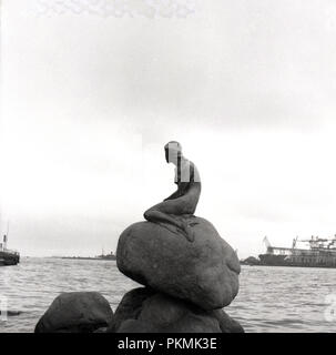 1950, historische, die Bronzeskulptur von Edvard Eriksen, 'Der kleine Mermiad' am Hafen Langelinie, Kopenhagen, Dänemark. 1913 erbaut und auf ein Zeichen aus einem Märchen von Hans Christian Andersen. Stockfoto