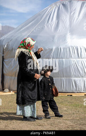 See Issyk-Kul, Kurgyzstan, 6. September 2018: Lokaler Junge in der Kirgisischen Outfit mit seiner Großmutter während der Welt Nomad Spiele 2018 Stockfoto