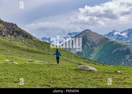 Trekker auf hohe Weide mit Terskey Ala-Too Bergkette im Hintergrund, Keskenkyia Loop trek, Jyrgalan, Kirgisistan Stockfoto