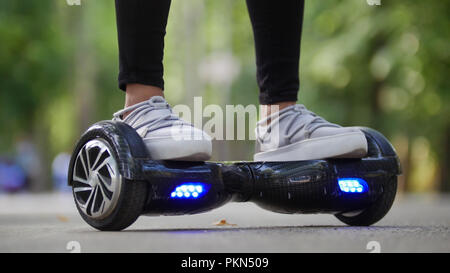 Weibliche Beine in Turnschuhen auf den steilen gyrometer. Reiten in den Park. Stockfoto