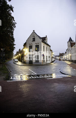 Gent, Belgien - 05 September, 2018: Die alten Backsteinhaus mit Reliefs an der Wand und kleinen Laden mit rote Tür mit Kunden am 05. September 2018. Stockfoto