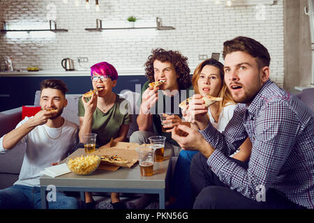 Eine Gruppe von Freunden essen Pizza beim Sitzen auf der Couch. Stockfoto