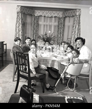 1950er Jahre, historische, Kaffee Kinder - Zeit ... eine glückliche Mutter genießen Nachmittagstee um einen Esstisch mit einer Gruppe von neun jungen Kinder, England, UK. Stockfoto