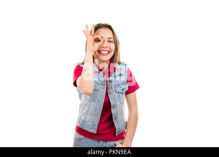 Junge casual Frau, OK Geste schauen durch die Finger von der Kamera auf weißem Hintergrund Stockfoto