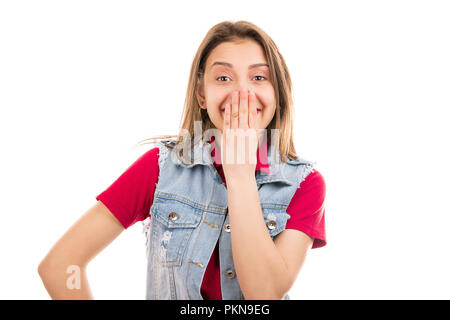 Hübsche Teenager Frau in Denim Weste für Mund in der Überraschung auf weißem Hintergrund Stockfoto