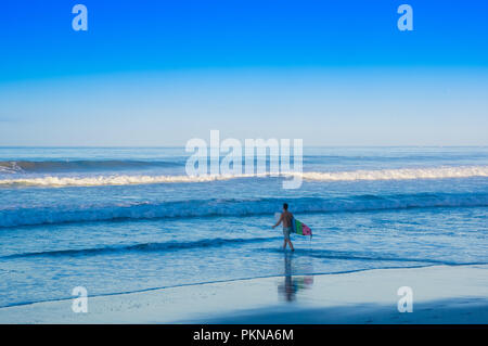 Santa Teresa, Costa Rica - Juni, 28, 2018: Jugendliche gehen in der Strand von Santa Teresa mit seinem Surfboard bereit zum Surfen in einem schönen, sonnigen Tag mit blauen Himmel und blaues Wasser Stockfoto
