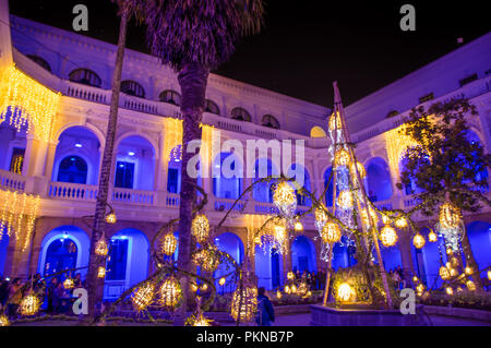 QUITO, ECUADOR - August, 15, 2018: Indoor Ansicht von Menschen mit Bildern in der kolonialen Gebäude mit bunten Lichtern während des Quito licht Festival Stockfoto