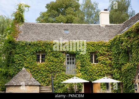 Einen malerischen Innenhof in den Cotswolds Dorf Lower Slaughter mit üppigen grünen kriechende Efeu für Gebäude aus Stein Stockfoto