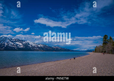 Gruppe von Touristen sitzen auf dem Boden genießen der Landschaft des Grand Teton National Park, Wyoming, Reflexion von Bergen auf der Jackson Lake in der Nähe von Yellowstone Stockfoto