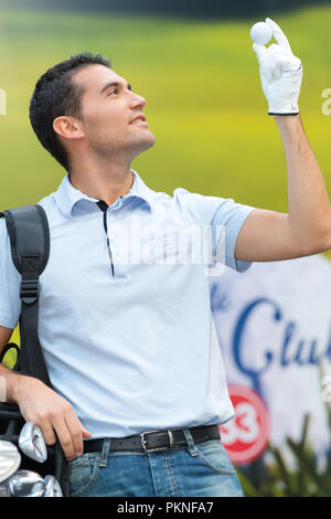 Golfspieler holding Ball und Golf Club Stockfoto