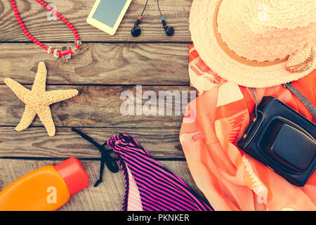 Sommer der Frauen Strand Zubehör für Ihr Meer Urlaub auf dem alten Holz- Hintergrund. Getönten Bild. Stockfoto