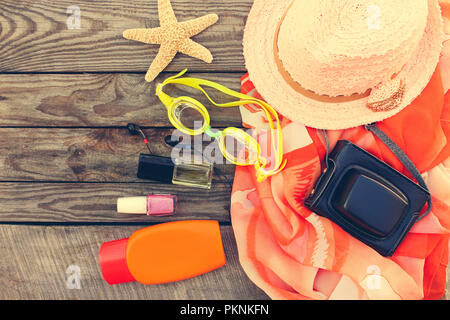 Sommer der Frauen Strand Zubehör für Ihr Meer Urlaub auf dem alten Holz- Hintergrund. Getönten Bild. Stockfoto