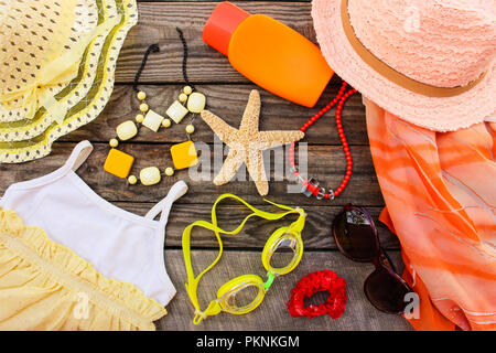 Der Sommer Damen Kleidung und Zubehör für ihren Strand Meer Urlaub auf alten hölzernen Hintergrund. Getönten Bild. Stockfoto