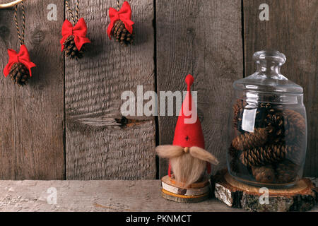 Winter Home Decor. Weihnachten rustikal eingerichtet. Bauernhaus Dekoration Stil. Dekorative gnome und ein Glas Kegel Stockfoto