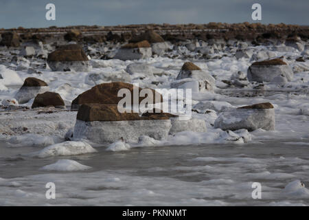 Vereisten Felsen der Küste der Hudson Bay in Manitoba, Kanada. Die tida; Shift hat Eis auf den Felsen links. Stockfoto