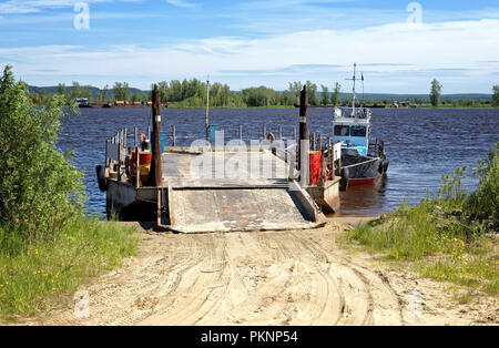 Leere Binnenschiff mit Rampe und Boot auf der Pier. Lieferung von Gütern und Personen in Sibirien Stockfoto