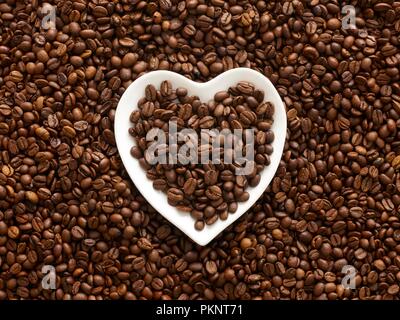 Kaffeebohnen in eine Herzform Schüssel. Stockfoto
