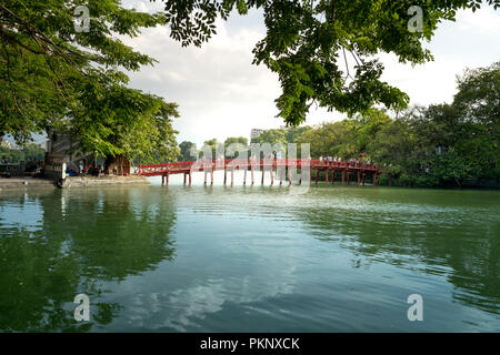 Touristen zu Fuß auf den Roten Die Huc Brücke zu den Ngoc Son Tempel auf dem See in Hanoi. Stockfoto