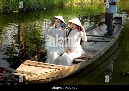 Zwei vietnamesische Mädchen sind sanfte in Kultur traditionellen weißen langen kleid auf dem Boot in der Stadt Hue, Vietnam Stockfoto