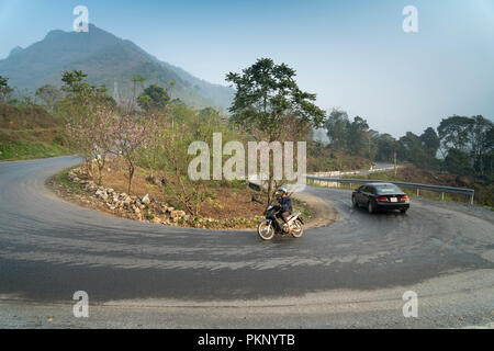 Ein Motorrad drehen auf geschwungene Straße runter vom Berg in Ha Giang Provinz im Norden von Vietnam Stockfoto