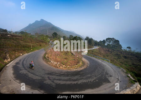 Ein Motorrad drehen auf geschwungene Straße runter vom Berg in Ha Giang Provinz im Norden von Vietnam Stockfoto