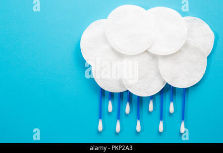 Bewoelkt und Regen aus Wattestäbchen und Baumwolle Scheiben auf blauem Hintergrund Stockfoto