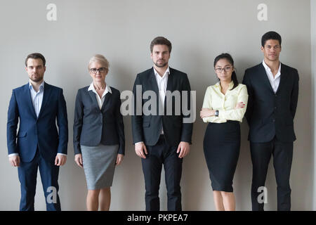 Junge und gestandene Geschäftsleute gemeinsam in der Zeile Stockfoto