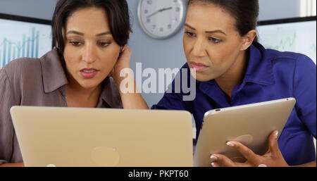 Afrikanische und Mexican American Business Frauen mit Laptop und Tablet-PC Stockfoto
