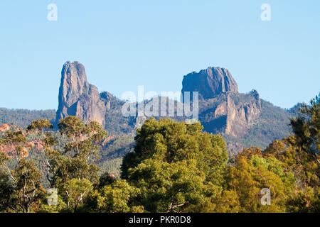 Schroffe Felsen ragen die bewaldeten Bereiche in blauer Himmel im warrumbungle National Park NSW Australien Stockfoto