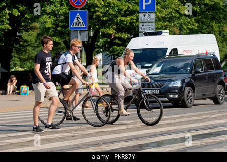 RIGA, Lettland - 18. JULI 2018: Radfahrer und Fußgänger die Straße überqueren, durch eine Fußgängerampel. Stockfoto