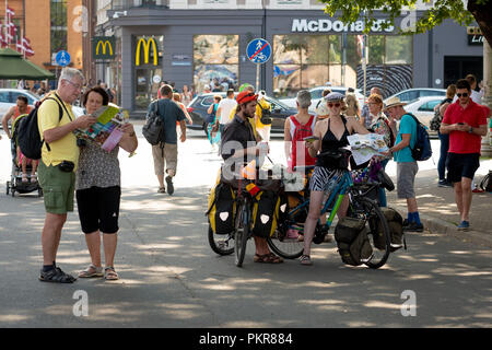 RIGA, Lettland - 18 Juli 2018: Das Fahrrad Touristen Halt in der Innenstadt auf der Straße und die Karte ansehen. Stockfoto