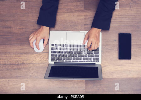 Business Mann mit Laptop auf hölzernen Hintergrund arbeiten, Asian Business Mann arbeitet oder die Suche in Laptop Stockfoto