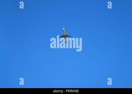 Flugzeug In vibrant blue Clear Sky fliegen mit freier Platz für Text und Gestaltung Stockfoto