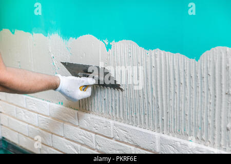 Fliesenleger Anwendung fliesenkleber an der Wand Stockfoto