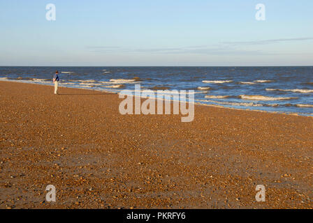 Einsame Mann am Meer beobachten die Wellen brechen, am frühen Morgen, Hunstanton, Norfolk, England Stockfoto