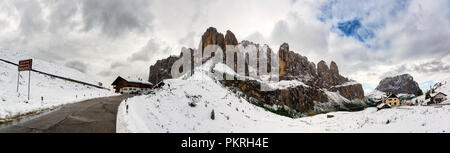 Berg Straße der Grödner Joch mit schneebedeckten Landschaft in den Bergen der Gruppe der Sella und bewölkter Himmel, Gröden - Trentino-Südtirol, Italien Stockfoto