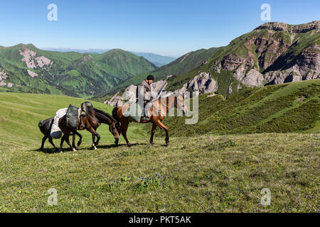 Kirgisische Reiter und Pferde mit Tyup River Valley im Hintergrund, Keskenkyia Loop trek, Jyrgalan, Kirgisistan Stockfoto