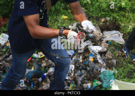 Meulaboh, Aceh, Indonesien. 15 Sep, 2018. Eine männliche Freiwillige räumt den Müll auf dem Boden. Welt Cleanup Day ist ein globales soziales Aktionsprogramm mit dem Ziel, globale Abfälle Probleme zu bekämpfen. Heute sind es 157 Länder, 380 Millionen Freiwilligen rund um die Welt teil der Reinigung trashes von der Straße Seiten und Entwässerung. Credit: Mimi Saputra/SOPA Images/ZUMA Draht/Alamy leben Nachrichten Stockfoto