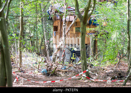 15. September 2018, Nordrhein-Westfalen, Kerpen: ein Feuerwehrmann ist an einer Hütte im Hambacher Forst. Mindestens eine Person sagte, in der Hütte, für mehr als 24 Stunden verankert worden zu sein. Das Spiel im Hambacher Forst wird fortgesetzt. Foto: Christophe Kirschtorte/dpa Stockfoto