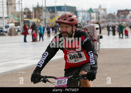 Blackpool, Lancashire, UK. 15. Sep 2018. "Pedal zum Pier" Mencap Off road Radfahren 100 km Herausforderung. Schlamm spritzt - Konkurrent 863 nähert sich dem Ziel nach einem strapaziösen 60 Meile Nächstenliebe off-road fahren sie mit dem Fahrrad von Manchester nach Blackpool, endumwandlung am Turm Landspitze. Kredit; MediaWorldImages/AlamyLiveNewsMencap Off road Radfahren 100 km Herausforderung. Schlamm spritzt - Konkurrent Ansätze die Ziellinie nach einem äußerst strapaziösen 60 Meile Nächstenliebe off-road fahren sie mit dem Fahrrad von Manchester nach Blackpool, endumwandlung am Turm Landspitze. Kredit; MediaWorldImages/AlamyLiveNews Stockfoto