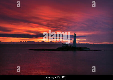 Die Sonne geht hinter der St Mary's Leuchtturm in Whitley Bay, Tyne und Wear. Stockfoto