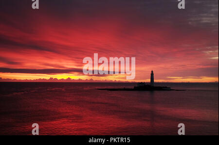 Die Sonne geht hinter der St Mary's Leuchtturm in Whitley Bay, Tyne und Wear. Stockfoto