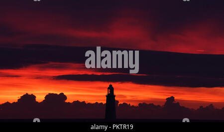 Die Sonne geht hinter der St Mary's Leuchtturm in Whitley Bay, Tyne und Wear. Stockfoto