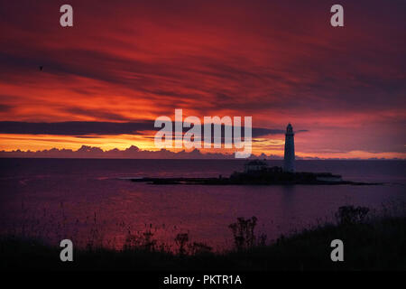 Die Sonne geht hinter der St Mary's Leuchtturm in Whitley Bay, Tyne und Wear. Stockfoto