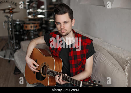 Hübscher junger Mann im Hemd holding Gitarre Stockfoto
