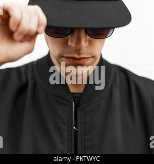 Stilvolle junger Mann in Sonnenbrille und eine schwarze Kappe Stockfoto